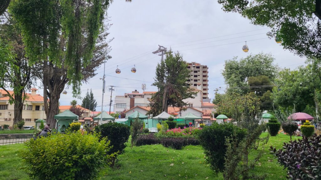 Yellow cable car line above park in La Paz