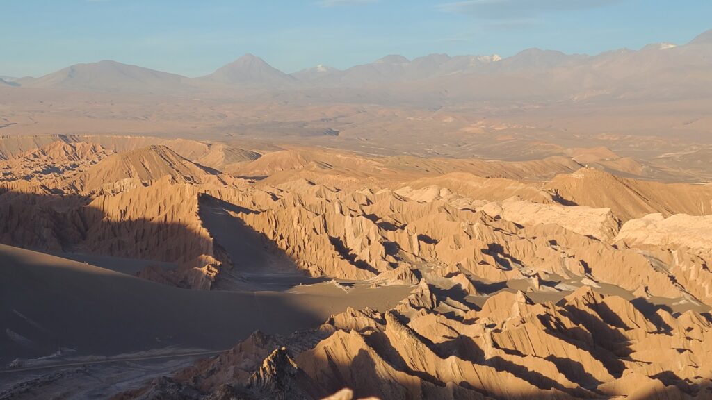 Golden hour in the Atacama Desert with rock formations coming out of sand